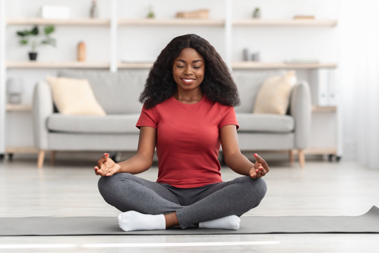 Peaceful Black Woman Meditating Alone at Home